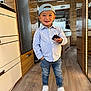 Peter a rejoint le concours — aidez-le/la à gagner de superbes lots ! child, toddler, boy, indoor, smiling, cap, striped_shirt, jeans, sneakers, wood_floor, remote_control, cabinet, mirror, bed, lighting, furniture, happy, standing, casual_clothing, modern_interior