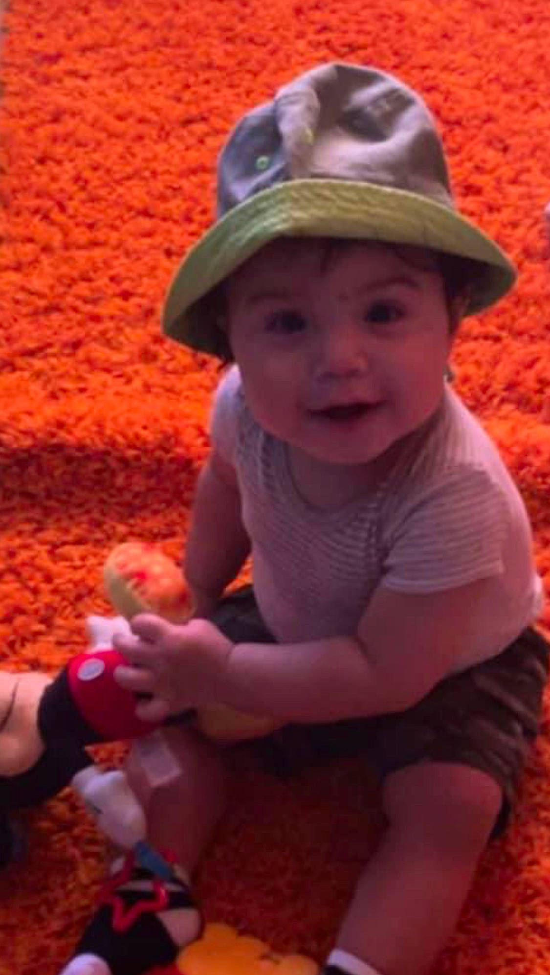 Marcus joined the competition — help win amazing prizes! baby, baby_toddler_clothing, cap, child, fashion_accessory, fun, grass, happy, hat, headwear, human_body, leisure, orange, people_in_nature, person, pink, play, recreation, sitting, skin