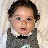 Noah Lucas Mattheo participe au concours pour gagner de l'argent avec cette photo : baby, child, face, blue_eyes, curly_hair, vest, bow_tie, white_shirt, blanket, soft_texture, portrait, cute, infant, indoor, closeup, expression, person, clothing, newborn, lying_down