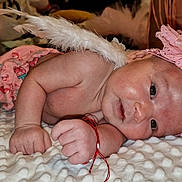 Selena participe au concours pour gagner de l'argent avec cette photo : baby, infant, angel, feather_wings, pink_headband, flower, blanket, cute, lying_down, soft_texture, skin, hand, face, expression, indoors, cozy, newborn, clothing, accessory, portrait