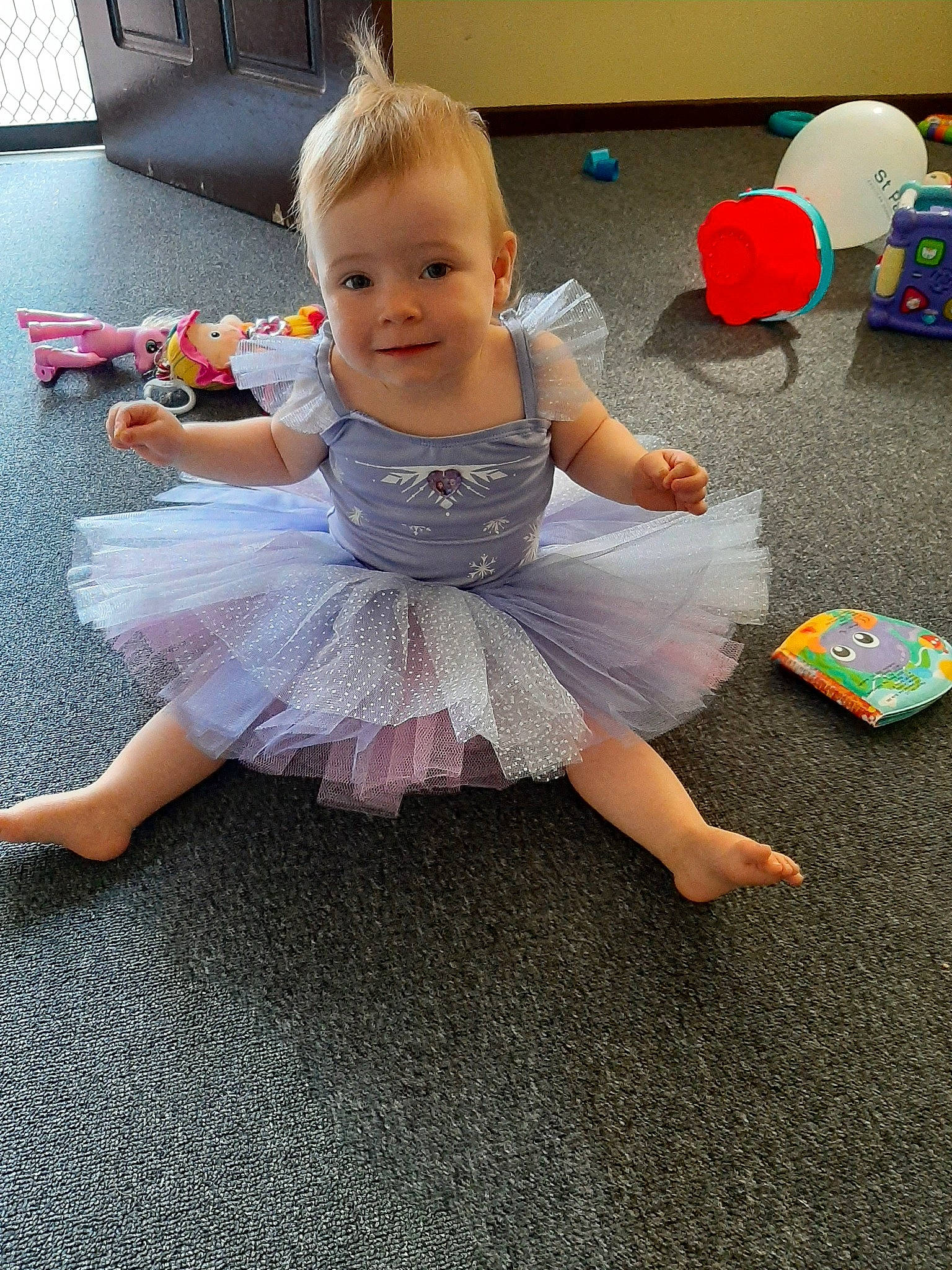 Cynthia is registered to the contest to win money with this photo: baby, ballet_tutu, child, costume, dress, floor, flooring, footwear, fun, joy, person, play, room, shoe, sitting, toddler