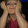 blue_eyes, cheeks, child, close_up, dark_background, dvd_player, flash_photography, funny_face, girl, hands, home, indoor, long_hair, photograph, pink_dress, playful, portrait, sitting, smiling, television