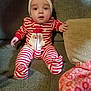 Colton is registered to the contest to win money with this photo: baby, child, pajamas, striped_clothing, santa_claus, couch, blanket, indoor, portrait, infant, cute, red_and_white, seated, cozy, face, person, home, soft_light, expression, hand