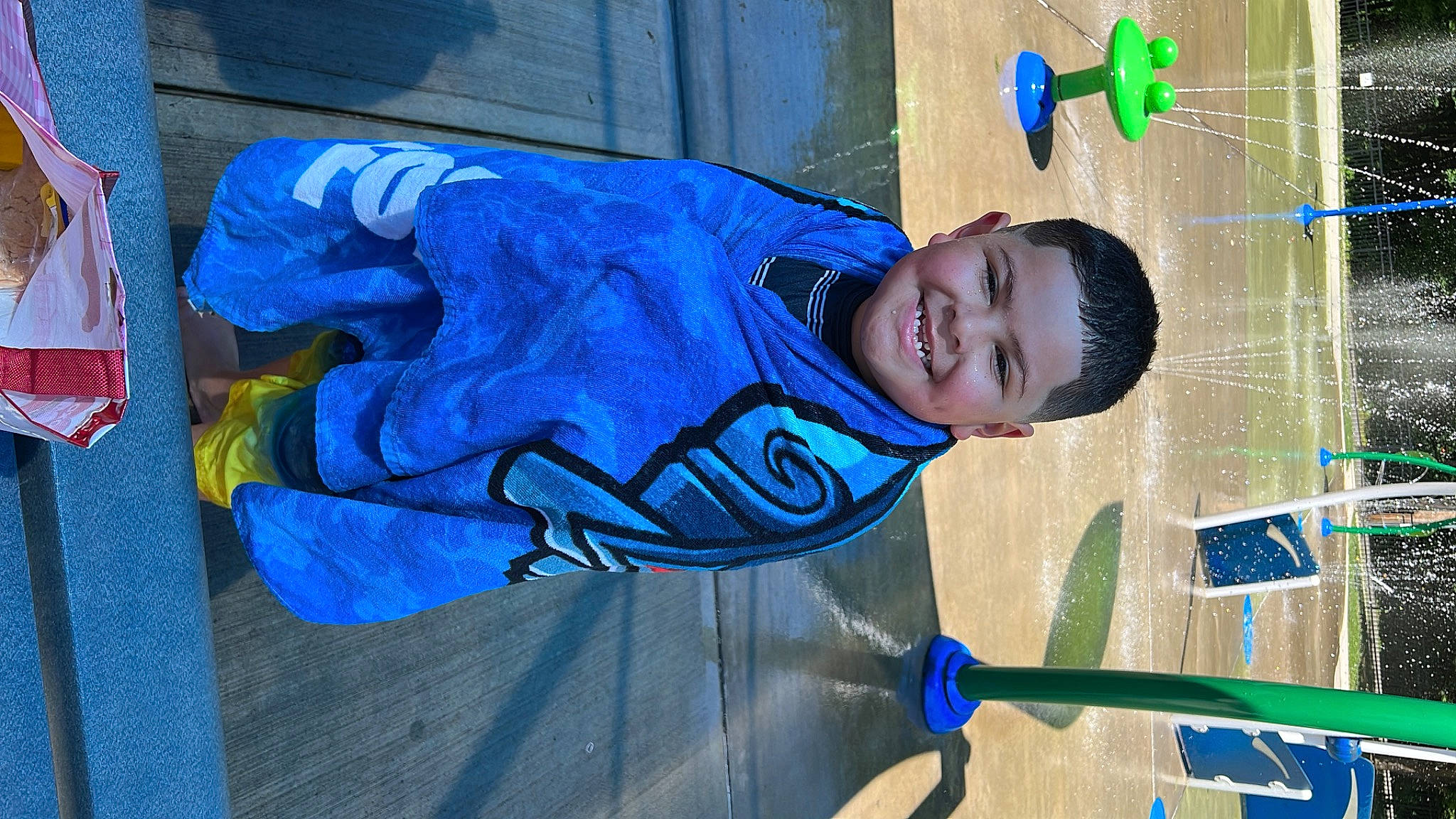 Wyatt is registered to the contest to win money with this photo: azure, blue, child, concrete, electric_blue, fun, happy, hat, joy, leisure, person, play, sleeve, smile, t_shirt, toddler, walking_shoe, water, world