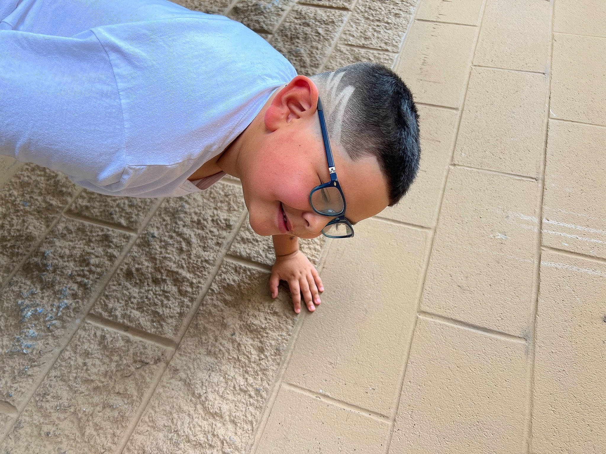 Wyatt joined the competition — help win amazing prizes! cap, child, concrete, eyewear, finger, flooring, fun, glasses, grass, hand, happy, human_leg, leisure, person, road_surface, sidewalk, sitting, sunglasses, t_shirt, toddler