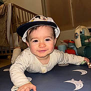 Tommy a rejoint le concours — aidez-le/la à gagner de superbes lots ! baby, cap, child, clothing, crawling, crib, cute, expression, face, floor, hand, hat, indoor, infant, mickey_mouse, person, play_mat, room, smile, toys