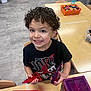 blocks, boy, child, classroom, curly_hair, education, floor, happy, indoor, learning, person, plastic_shapes, play, preschool, purple_container, red_container, smiling, table, toys, wooden_chairs