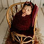 Aitana joined the competition — help win amazing prizes! newborn, baby, sleeping, infant, wicker_chair, swaddled, headband, pillow, cozy, soft_texture, burgundy, wrapped, peaceful, portrait, indoors, wood_floor, decor, cute, resting, baby_photography