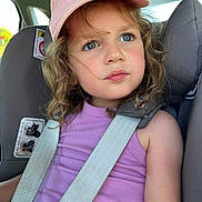 Clémence participe au concours pour gagner de l'argent avec cette photo : child, girl, car_seat, seatbelt, pink_cap, purple_tank_top, curly_hair, blue_eyes, car_interior, safety_strap, window, daylight, portrait, cute, young_person, expression, casual_clothing, closeup, seat, summer