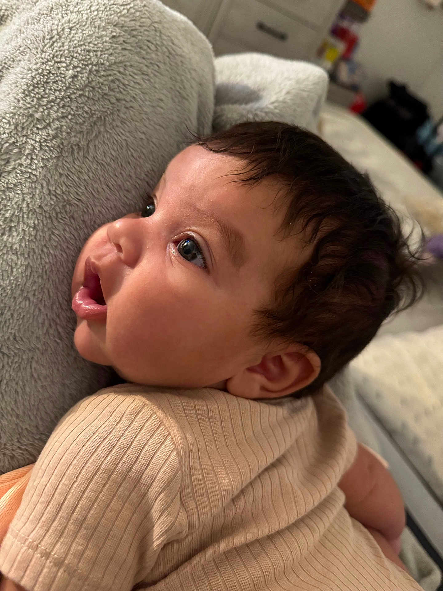 Kylie is registered to the contest to win money with this photo: baby, child, infant, face, side_profile, curly_hair, blanket, soft_texture, indoors, cute, expression, skin, clothing, short_sleeves, resting, young, portrait, person, closeup, newborn