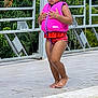 child, life_jacket, pool, water, swimming, barefoot, outdoor, tiles, safety, summer, young_girl, pink, red, standing, concentration, waterproof, fence, greenery, daytime, vacation