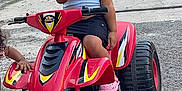 Kloe joined the competition — help win amazing prizes! child, helmet, toy_vehicle, quad_bike, red, street, sidewalk, curious, outdoor, casual_clothing, shorts, pink_shoes, hand, asphalt, urban, daytime, play, helmet_visor, person, kid