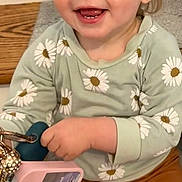 Amelia joined the competition — help win amazing prizes! toddler, child, smiling, sitting, stairs, hair_clip, green_shirt, daisy_pattern, mustard_pants, holding_phone, happy, indoor, wooden_stairs, cute, young_child, portrait, casual_clothing, small_earrings, playful, light_hair