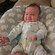 Emerson is registered to the contest to win money with this photo: baby, infant, smiling, onesie, elephant_pattern, nursing_pillow, pacifier, tattooed_hand, hand, couch, living_room, carpet, pillow, cozy, portrait, baby_clothes, happy, fuzzy_hair, plush_pattern, indoor