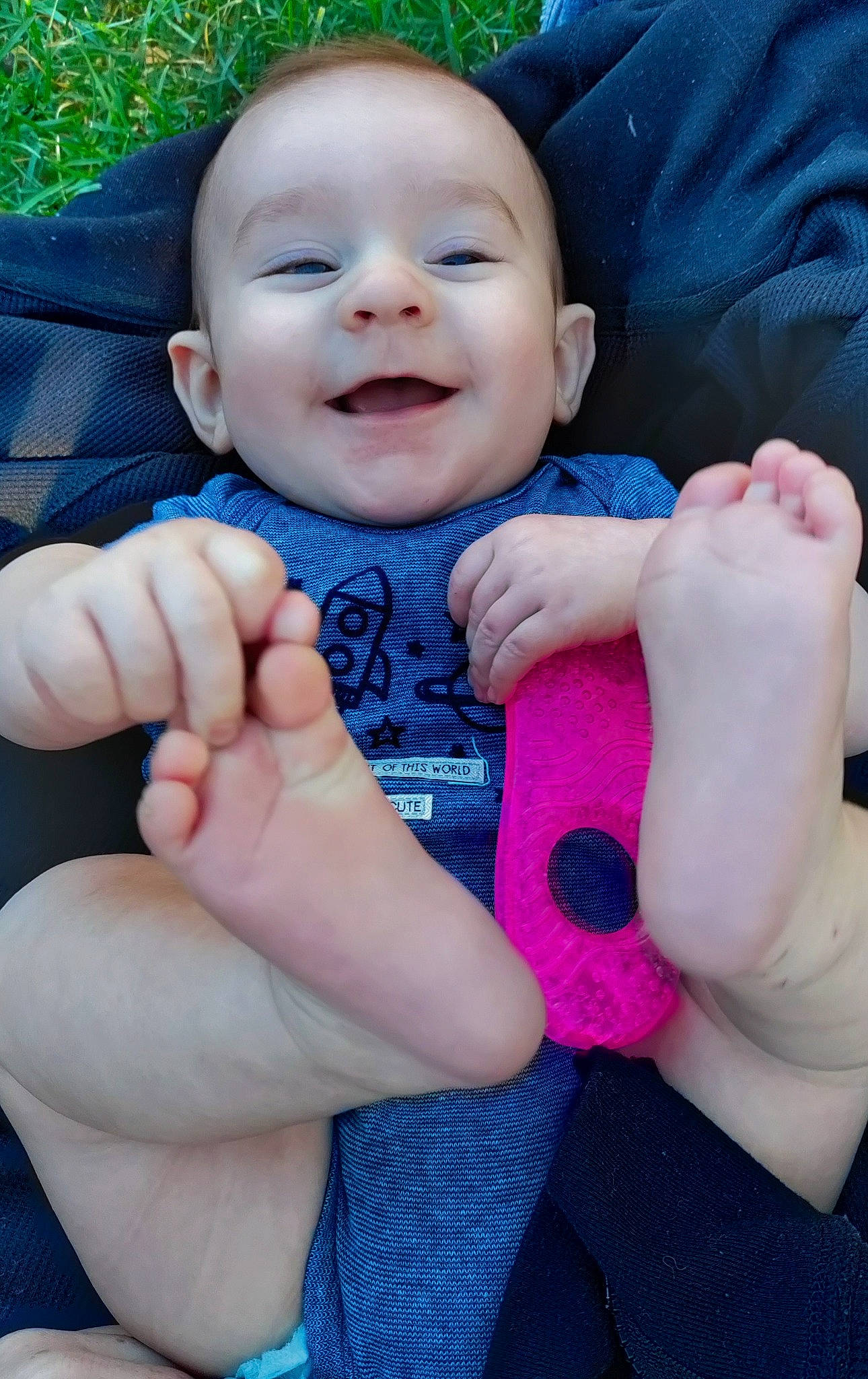 Lucius is registered to the contest to win money with this photo: arm, baby_toddler_clothing, blue, cheek, chin, eye, face, finger, gesture, hand, happy, head, lip, nose, people_in_nature, person, pink, skin, sleeve, smile