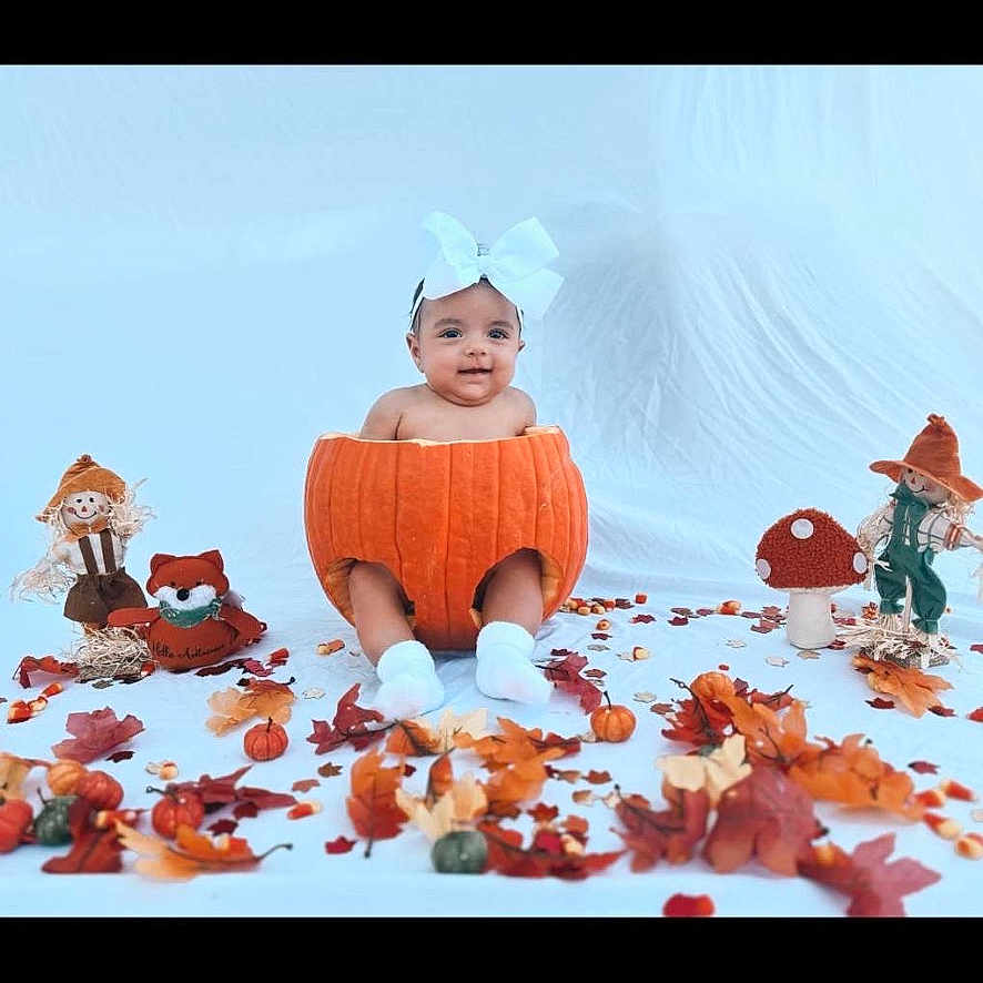 Oaklynn is registered to the contest to win money with this photo: baby, cap, clothing, face, flower, happy, hat, head, hosiery, leaf, person, petal, photography, plant, portrait, pottedplant, sitting, smile, sock, tree