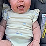baby, infant, onesie, car_seat, smiling, tongue_out, cute, chubby_cheeks, comfortable, child, seated, clothing, indoor, portrait, happy, person, skin, face, young, expression