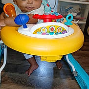 Jeremiah joined the competition — help win amazing prizes! baby, walker, toy, floor, indoor, child, curious, person, foot, plastic, colorful, seat, play, furniture, cabinet, storage, room, electric_outlet, cable, wood_floor