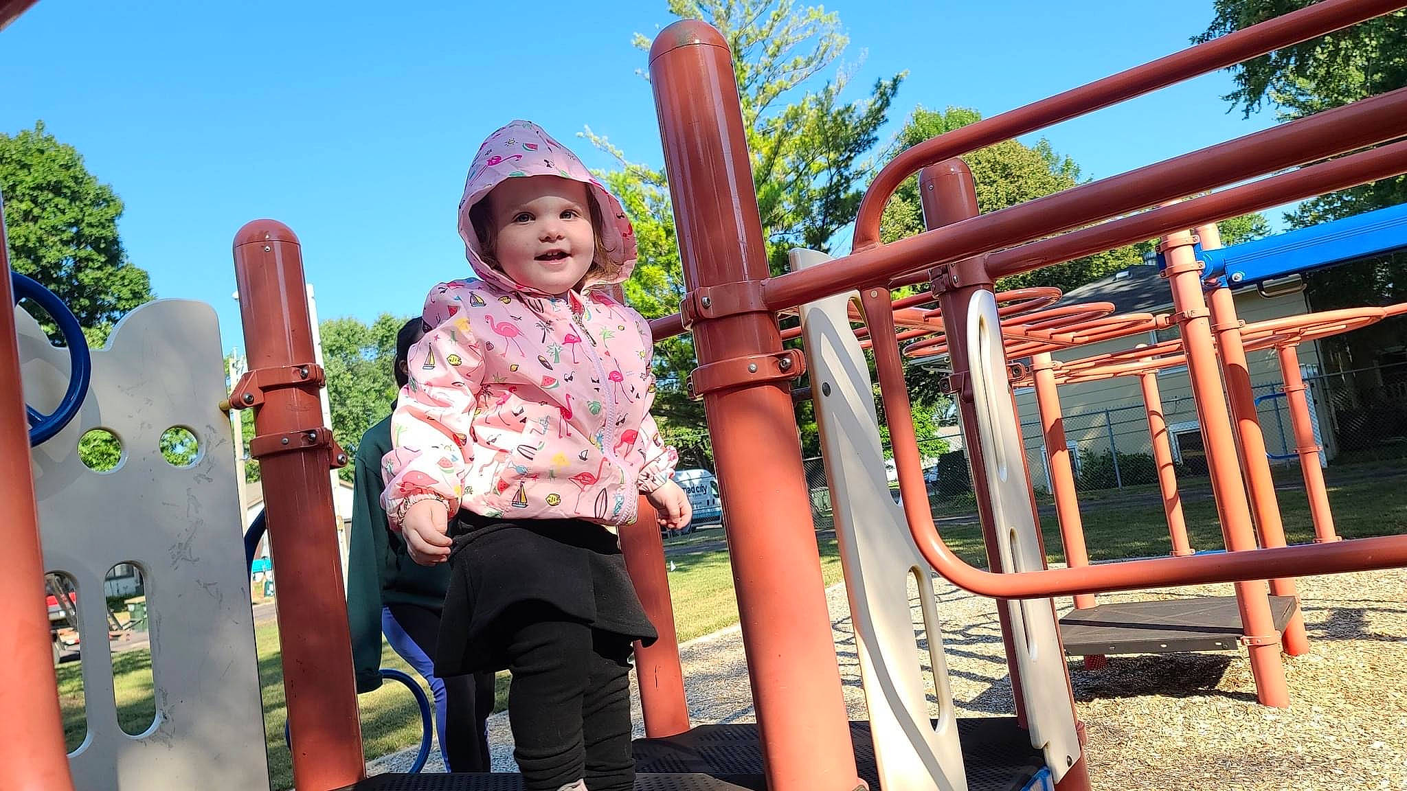 Paisley is registered to the contest to win money with this photo: child, chute, city, fun, grass, happy, headwear, joy, leisure, magenta, outdoor_play_equipment, person, plant, play, playground, playground_slide, recreation, sitting, sky, smile