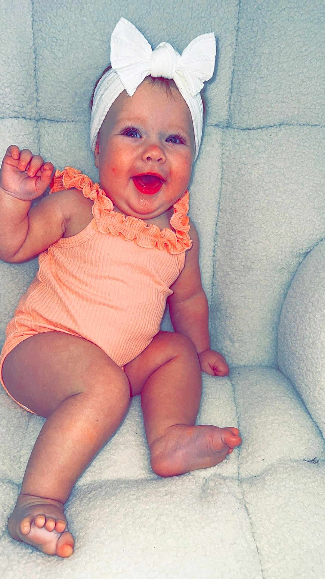 Suttyn is registered to the contest to win money with this photo: accessories, baby, babylaughing, bodypart, clothing, couch, cushion, dress, face, furniture, happy, hat, head, homedecor, laughing, person, photography, portrait, sitting, smile