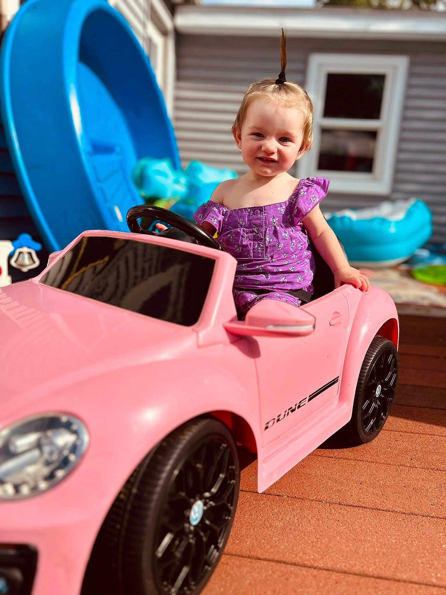 Aurora joined the competition — help win amazing prizes! toddler, child, toy_car, pink_car, outdoor, playground, purple_clothing, smiling, happy, daylight, playtime, backyard, vehicle, small_child, cute, portrait, summer, fun, young_child, casual