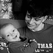 Atlas is registered to the contest to win money with this photo: baby, child, young_man, smile, happy, portrait, black_and_white, indoor, couch, clothing, person, holding, affection, family, curtains, floral_pattern, face, head, arm, casual_wear