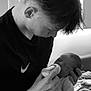 baby, bottle, feeding, black_and_white, boy, child, infant, newborn, person, portrait, young_adult, holding, love, care, indoor, bed, blanket, clothing, hair, skin