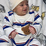 Kaÿden participe au concours pour gagner de l'argent avec cette photo : baby, infant, child, smiling, hat, knitwear, striped_clothing, shoes, white_shoes, blanket, animal_print, cute, cozy, sitting, portrait, happy, indoor, soft_texture, warm_clothing, person