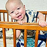 Carl is registered to the contest to win money with this photo: baby, crib, wooden_crib, child, smiling, happy, indoor, blanket, bed, pajamas, person, infant, cute, hands, foot, face, home, playful, toddler, sleepwear