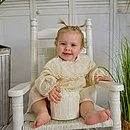 Myah joined the competition — help win amazing prizes! toddler, child, smiling, white_chair, cream_dress, cake, indoor, plant, wooden_floor, pigtails, happy, baby, portrait, seated, cute, decor, home, furniture, small_cake, person