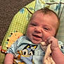 Violet is registered to the contest to win money with this photo: baby, infant, smile, face, clothing, hand, fabric, seat, pattern, carpet, indoor, comfort, cute, child, person, baby_seat, toy, closeup, expression, holding