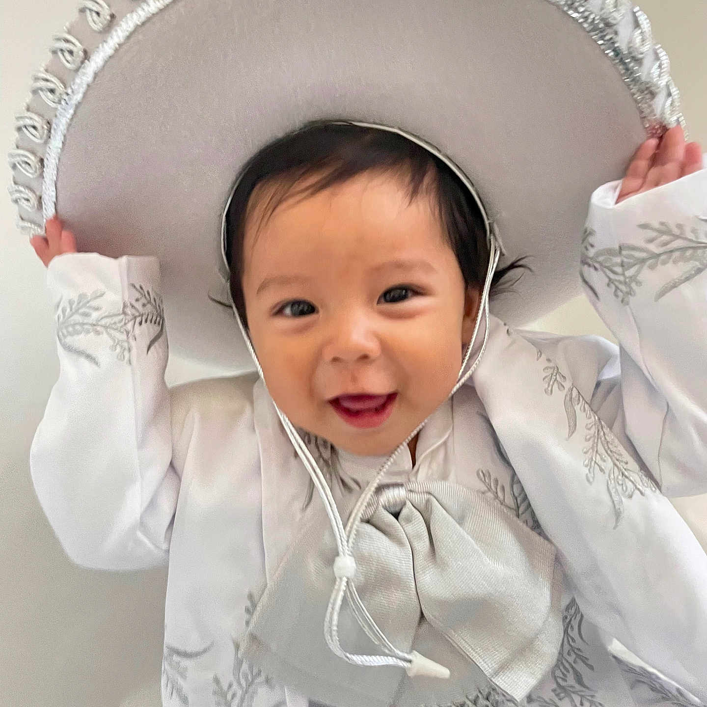 Jesús Emilio Vargas is registered to the contest to win money with this photo: baby, celebration, child, costume, cute, embroidery, face, fashion, festive, hands, happy, hat, indoors, portrait, smiling, sombrero, toddler, traditional_outfit, white_clothing, young_child