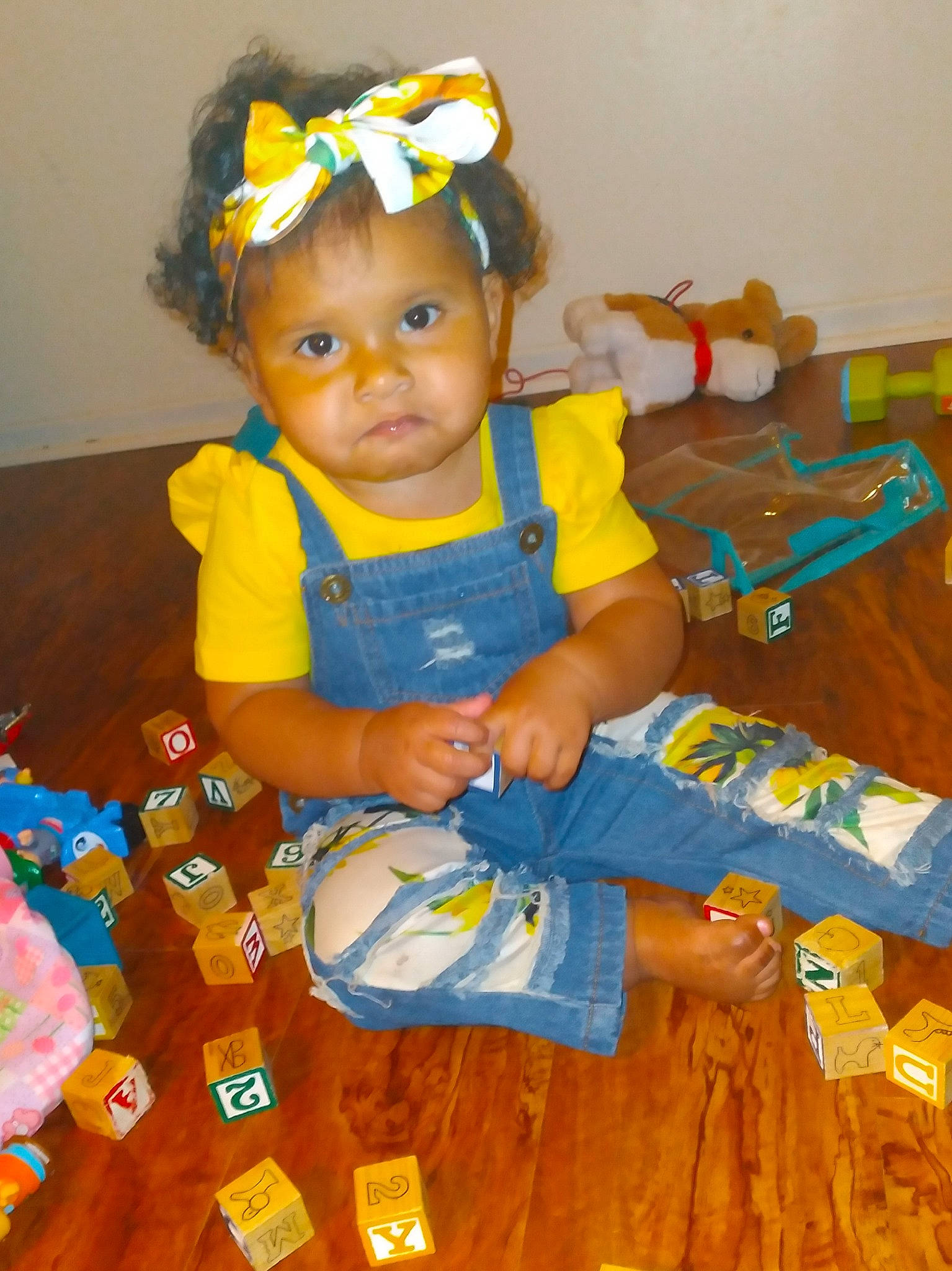 Mya is registered to the contest to win money with this photo: baby, baby_toddler_clothing, cheek, child, dress, eye, fashion_accessory, flooring, fun, goggles, happy, headband, headpiece, orange, pattern, person, sitting, skin, sleeve, sunglasses