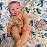 baby, infant, child, smiling, portrait, lying_down, tan_romper, blanket, sea_turtles, turtle_pattern, milestone_photo, five_months, wooden_sign, indoors, soft_lighting, happy, cute, nursery, textile, photography