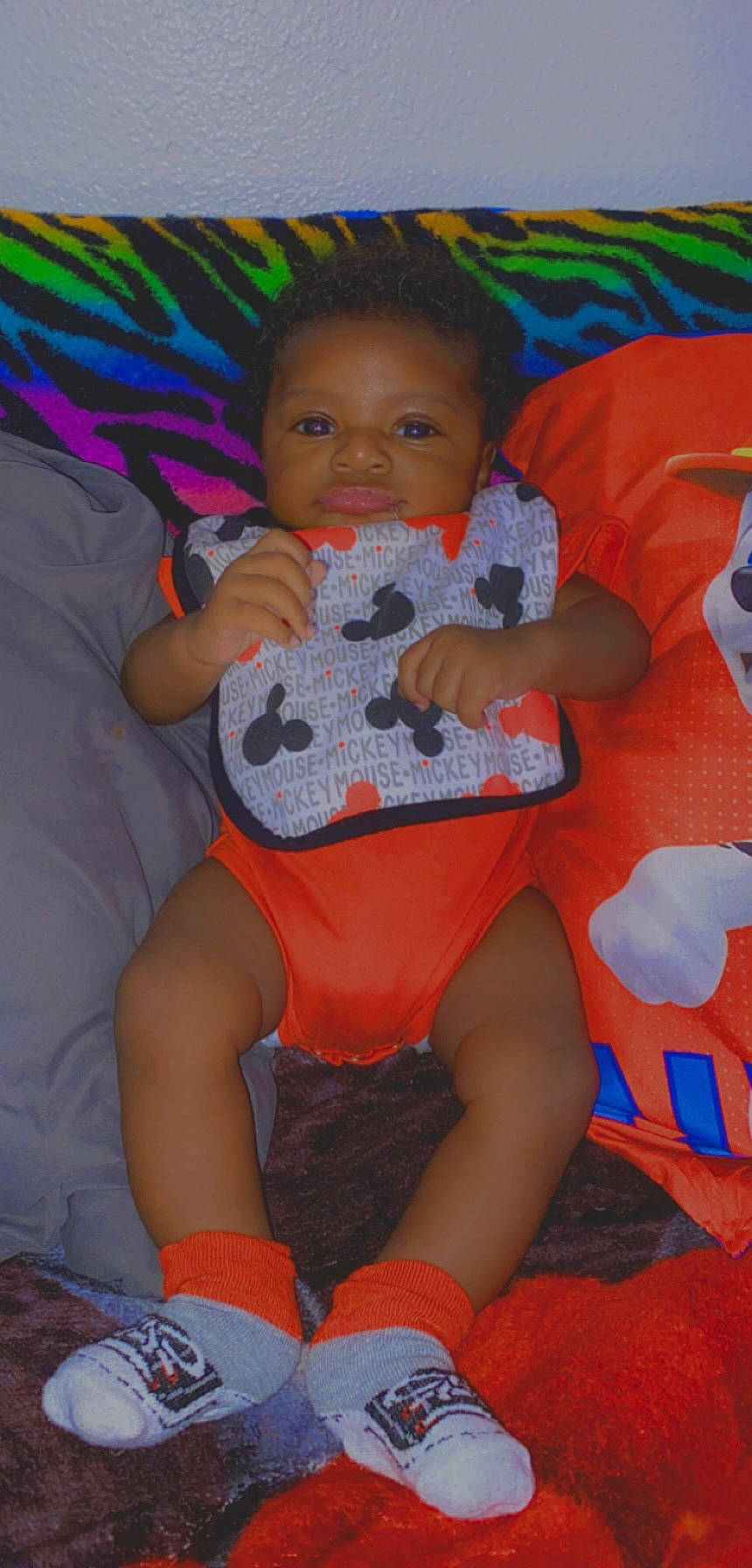 Antwan is registered to the contest to win money with this photo: baby, baby_toddler_clothing, comfort, finger, happy, lap, leg, mouth, orange, organ, person, red, shorts, skin, sleeve, smile, sock, t_shirt, textile, thigh