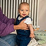 Valentin a rejoint le concours — aidez-le/la à gagner de superbes lots ! baby, infant, child, smiling, denim_overalls, blue_eyes, adult_hand, supporting_hand, indoor, radiator, toy, blanket, floor, portrait, cozy, playtime, cute, family, home, sitting