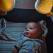 Jayce is registered to the contest to win money with this photo: baby, infant, child, portrait, lying_down, awake, wide_eyed, facial_expression, clothing, onesie, teddy_bear, plush_toy, striped_blanket, blanket, indoor, ceiling_light, soft_toys, bed, cozy, photography