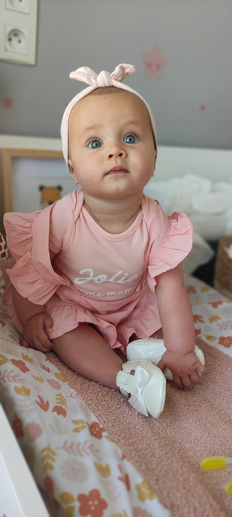 Noëllie participe au concours pour gagner de l'argent avec cette photo : arm, baby, baby_toddler_clothing, cheek, dress, eye, face, hand, head, human_body, iris, lip, mouth, nose, person, pink, product, skin, sleeve, toddler