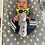 baby, smiling, infant, blanket, stars, clothing, socks, happy, cute, child, person, indoor, bed, playful, toddler, face, hands, feet, yellow, gray