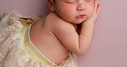 Jennie joined the competition — help win amazing prizes! newborn, baby, sleeping, headband, golden_bow, floral_skirt, pastel_background, soft_lighting, cute, infant, peaceful, portrait, closeup, adorable, skin, child, resting, toddler, small_feet, pink
