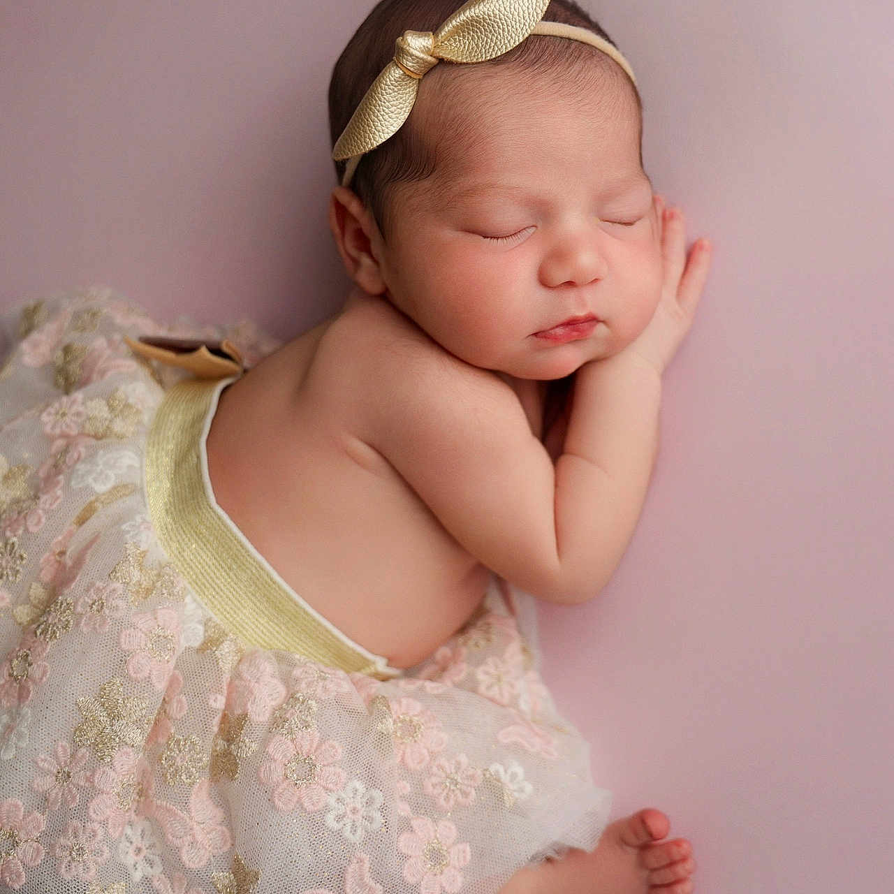 Jennie joined the competition — help win amazing prizes! newborn, baby, sleeping, headband, golden_bow, floral_skirt, pastel_background, soft_lighting, cute, infant, peaceful, portrait, closeup, adorable, skin, child, resting, toddler, small_feet, pink