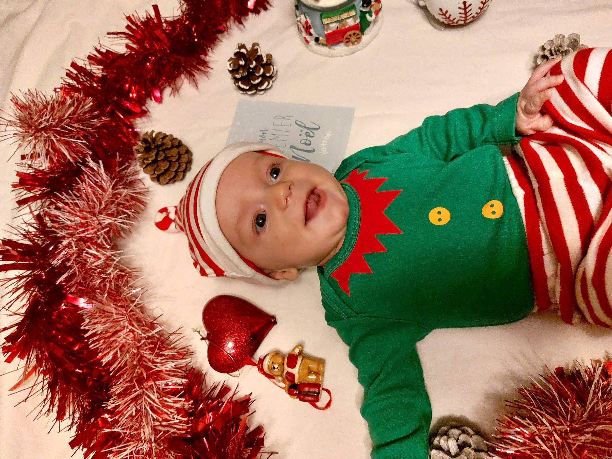 Gabin a rejoint le concours — aidez-le/la à gagner de superbes lots ! baby, christmas, christmas_decoration, christmas_eve, christmas_ornament, christmas_tree, event, face, facial_expression, happy, headwear, holiday, holiday_ornament, mammal, ornament, person, product, red, santa_claus, smile