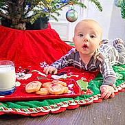 Colten is registered to the contest to win money with this photo: baby, child, christmas_tree, christmas_lights, cookies, milk, holiday, festive, pajamas, floor, ornaments, red, green, decoration, indoors, curious, celebration, tree_skirt, toddler, holiday_cheer