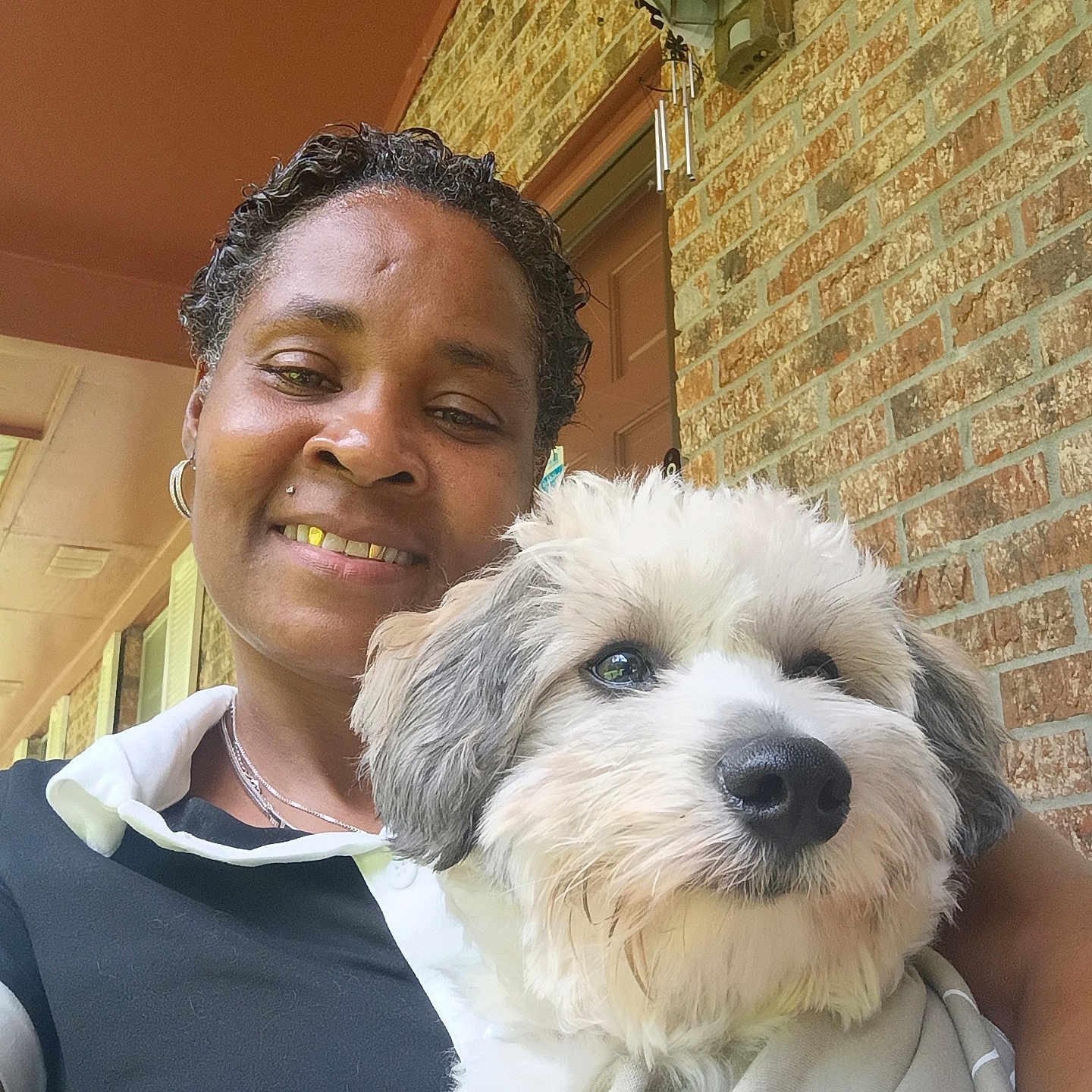 Twix Cardiar is registered to the contest to win money with this photo: animal, blanket, brick_wall, closeup, clothing, collar, dog, door, face, fluffy_dog, fur, happy, head, human, outdoor, person, pet, porch, portrait, smile