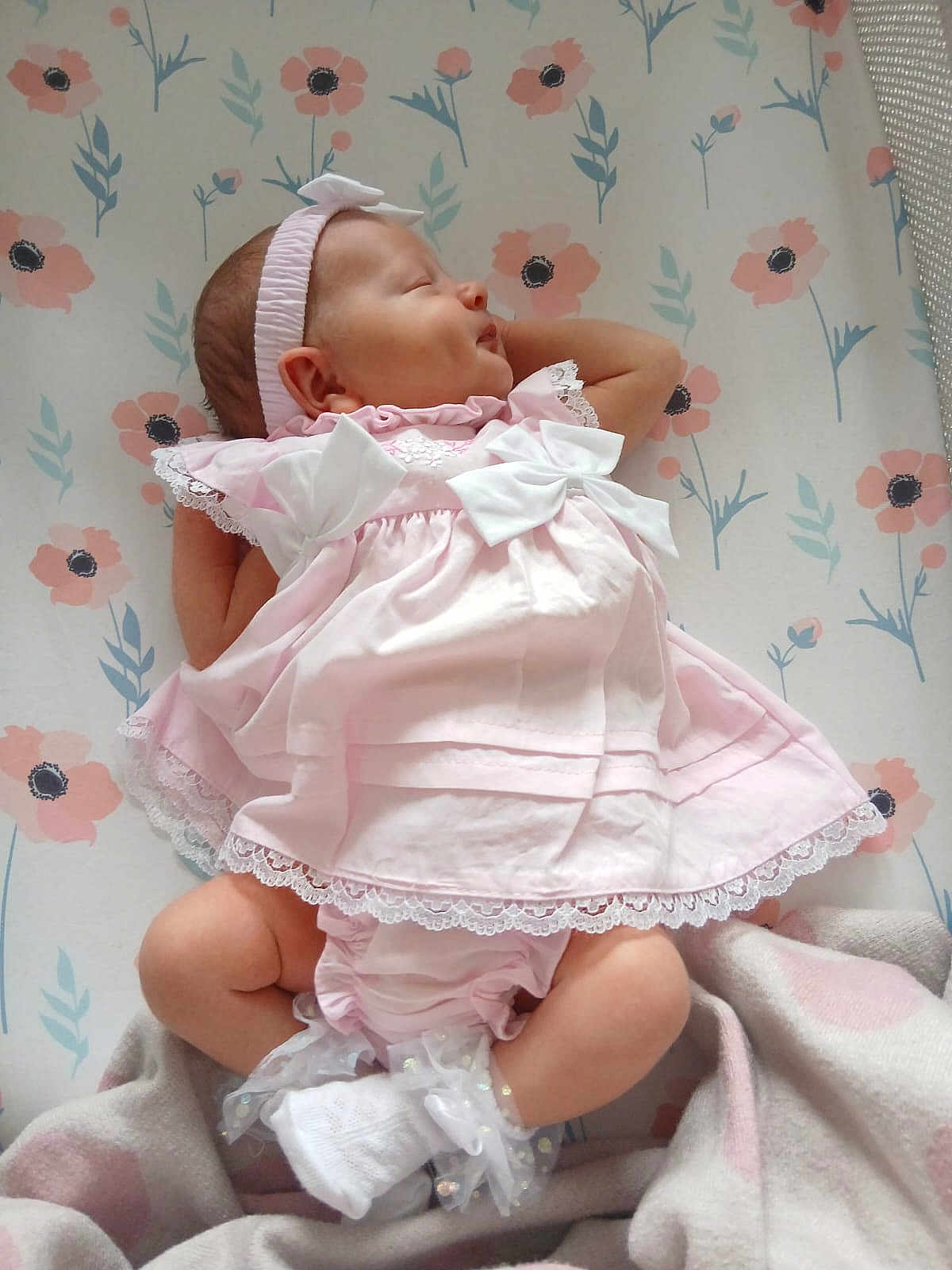 Florence is registered to the contest to win money with this photo: baby, infant, sleeping, dress, pink, bows, headband, blanket, floral_pattern, socks, cute, peaceful, newborn, soft, indoors, child, portrait, resting, small, adorable