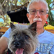 Murphy joined the competition — help win amazing prizes! background, casual, dog, face, glasses, happy, leisure, man, nature, outdoor, pet, portrait, red_harness, senior, smile, sunlight, t_shirt, tongue_out, trees, umbrella