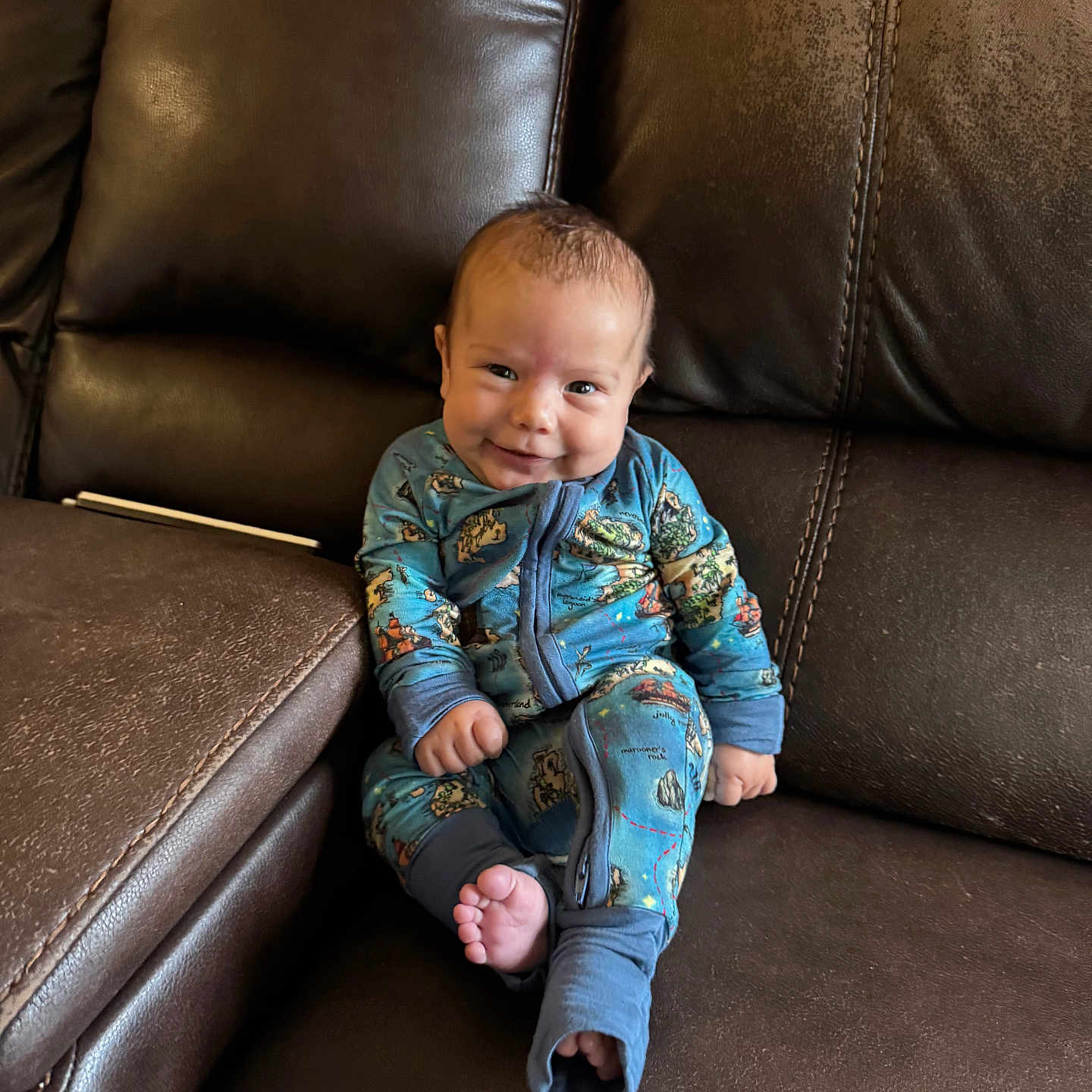 Clyde joined the competition — help win amazing prizes! baby, blue_clothing, child, comfort, couch, cozy, cute, face, foot, hand, happy, indoors, infant, leather, pajamas, portrait, relaxation, sitting, smile, young_child