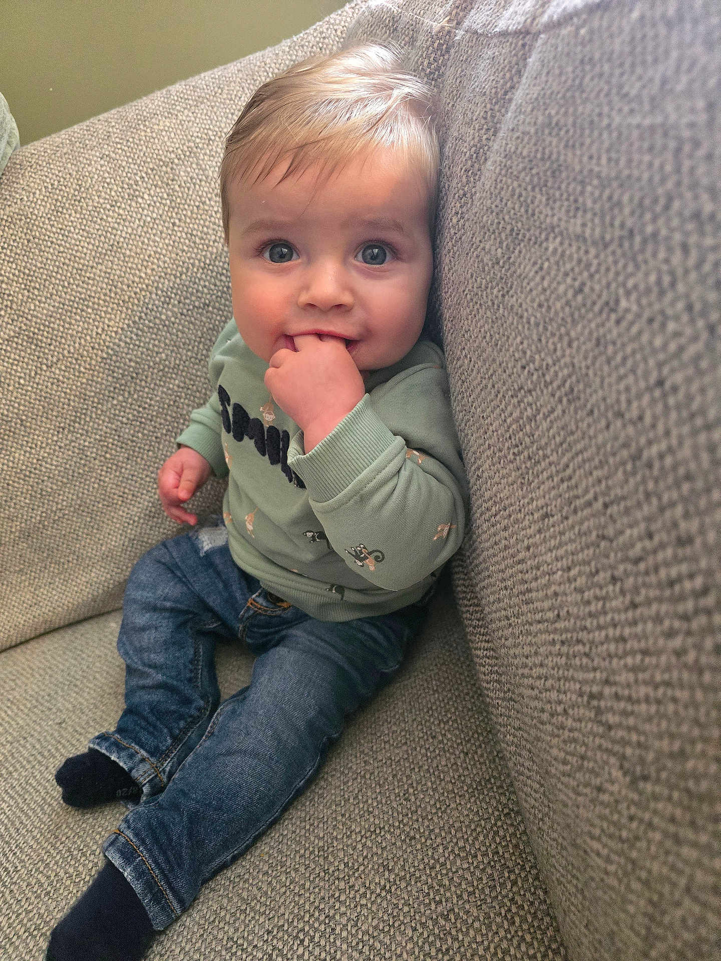 Achille participe au concours pour gagner de l'argent avec cette photo : baby, bodypart, clothing, coat, couch, cushion, face, finger, furniture, hand, head, homedecor, hosiery, jeans, pants, person, photography, portrait, sitting, sock
