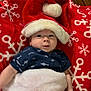 Angel L. B. is registered to the contest to win money with this photo: baby, infant, santa_hat, blanket, red, white, snowflake_pattern, holiday, festive, cute, face, clothing, wooden_floor, lying_down, cozy, warm, smiling, child, portrait, indoors