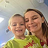 Zeke is registered to the contest to win money with this photo: adult, cartoon, casual_clothing, ceiling, child, closeup, face, family, green_shirt, happy, head_and_shoulders, indoor, light, people, person, portrait, selfie, smile, together, young_child